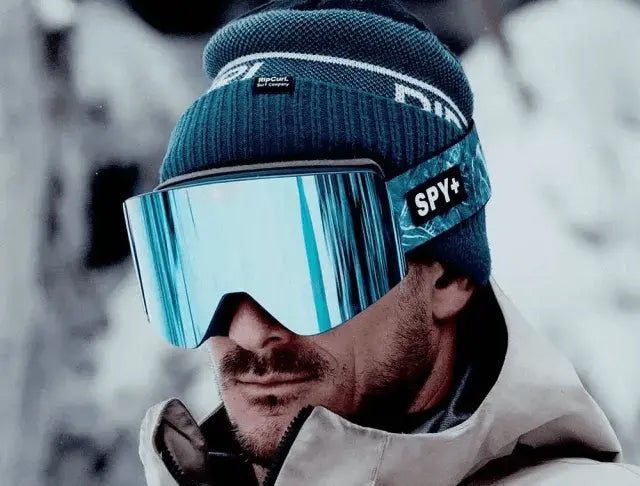 Skier wearing SPY goggles with a mirrored blue lens